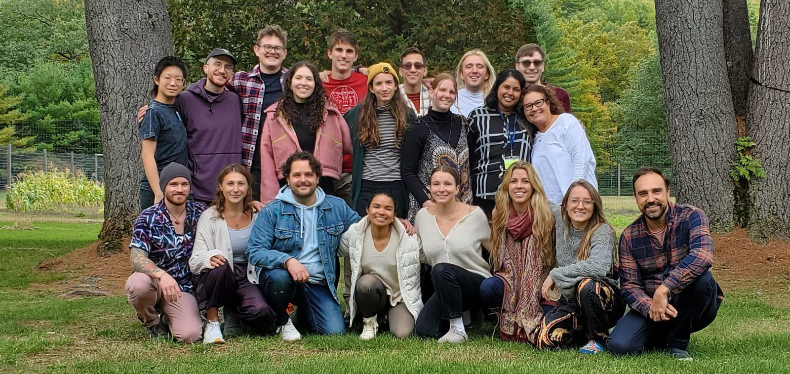 A large group of IPN members posing together beneath trees