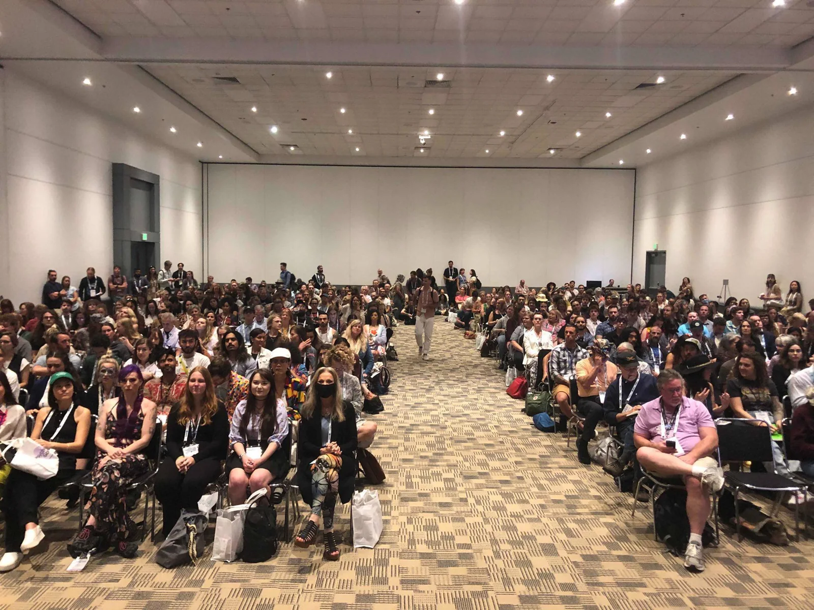 A conference audience smiling toward the camera